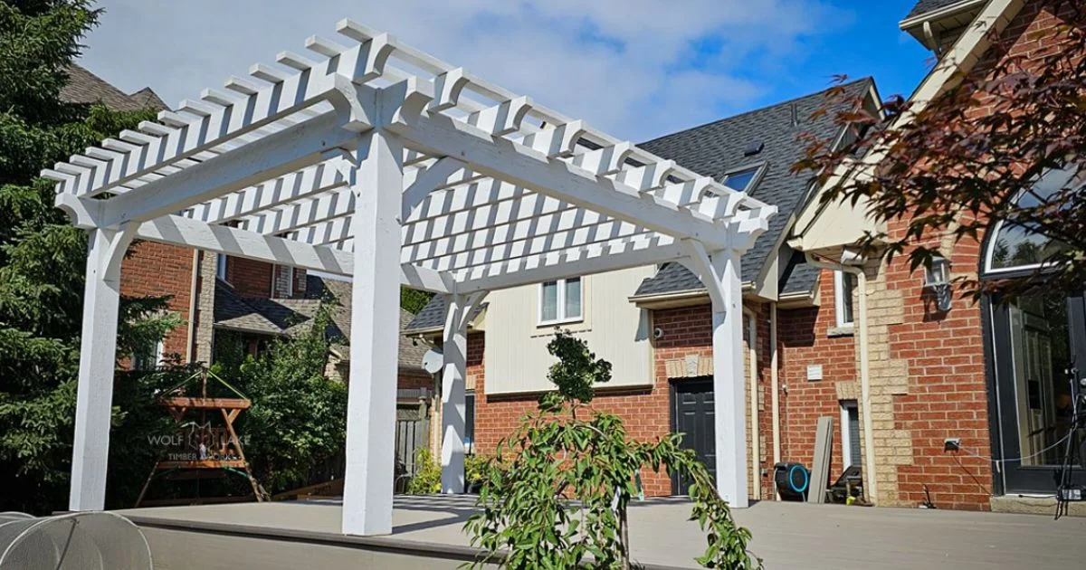 White pergola with brick house backdrop